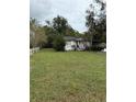 White single story house with American flags, green lawn, and white picket fence at 15518 State Road 19, Groveland, FL 34736