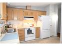 Bright kitchen features white appliances and light wood cabinets at 1153 Del Toro Dr, The Villages, FL 32159