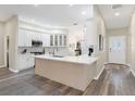 Modern kitchen with white cabinets, quartz countertops, and an island at 1514 Fenimore Ln, The Villages, FL 32162