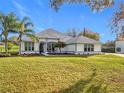 One-story house with landscaped lawn and palm trees at 36732 Barrington Dr, Eustis, FL 32736