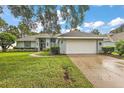 Light blue house with a white garage door and manicured lawn at 1720 Park Forest Blvd, Mount Dora, FL 32757