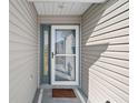 Front entry with storm door and welcome mat at 1711 Augustine Dr, The Villages, FL 32159