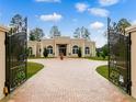 Grand estate home with brick driveway and wrought iron gates at 39851 & 39855 Darlington Ave, Lady Lake, FL 32159