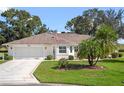 Single-story home with two-car garage and palm trees at 5416 Essex Ct, Leesburg, FL 34748