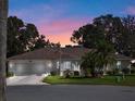 Single-story home with two-car garage, at dusk at 5416 Essex Ct, Leesburg, FL 34748