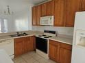 Kitchen with wood cabinets, microwave, oven, and dishwasher at 652 Chelsea Dr, Davenport, FL 33897