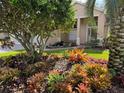 Landscaped front yard with tropical plants and a water feature at 21630 King Henry Ave, Leesburg, FL 34748
