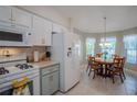 Bright kitchen with a dining area, white appliances, and wood-toned table at 3332 Flagship Ave, Tavares, FL 32778