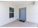 Light blue front door with sidelight and welcome mat at 5238 Dalessandro Rd, The Villages, FL 32163