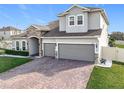 Two-story house with stone accents, three-car garage, and manicured lawn at 405 Amola Way, Howey In The Hills, FL 34737