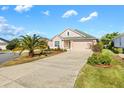 One-story house with a two-car garage and palm trees at 1429 Bluebeard Ct, The Villages, FL 32163