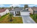 Single-story home with landscaped yard and compass at 2552 English Ivy Cir, The Villages, FL 32162