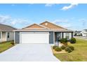 Front view of a two-car garage home with landscaping at 265 Zingale Ln, The Villages, FL 32163