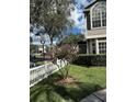 Landscaped front yard with a white picket fence and a small tree at 12144 Bruceton Way # 101, Orlando, FL 32828