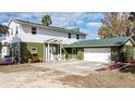 Two-story house with green and white siding, a large driveway, and a two-car garage at 13131 Mountain Vw, Clermont, FL 34715