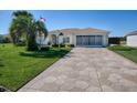 Well-maintained house with a large driveway and palm tree at 13544 Se 87Th Cir, Summerfield, FL 34491