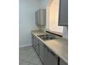 Kitchen features gray cabinets, double sink, dishwasher, and tile flooring at 13584 Turtle Marsh Loop # 132, Orlando, FL 32837