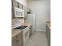 Modern kitchen with gray cabinets, stainless steel appliances, and tile flooring at 13584 Turtle Marsh Loop # 132, Orlando, FL 32837