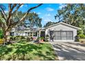 Front view of a single story house with a garage and driveway at 26726 Wimbledon St, Leesburg, FL 34748