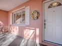 Inviting front porch with a sunflower wreath, white door, and a small table and chair set at 33236 Grand Cypress Way, Leesburg, FL 34748