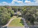 Spacious home with a large yard and circular driveway, surrounded by trees at 4626 Ne 7Th St, Ocala, FL 34470