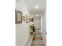 Bright hallway with wood-look floors and framed artwork on the walls at 4809 Magnetite Loop, Mount Dora, FL 32757