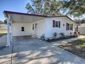 White single-story home with carport, landscaping, and a paved driveway at 1611 Cherry Hill Rd, The Villages, FL 32159