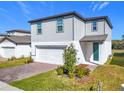 Two-story house with gray siding, white garage door, and landscaping at 30224 Armenia Rd, Leesburg, FL 34748