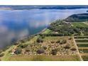 Aerial view showcasing a lakefront property with orchards at 38230 Yale Cir, Leesburg, FL 34788