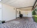 Covered patio area with brick pavers and a grill at 712 Tarrson Blvd, The Villages, FL 32159