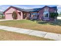Brick and shingle ranch home with a two-car garage and landscaped yard at 7715 Indian Ridge N Trl, Kissimmee, FL 34747