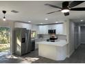 Modern kitchen featuring white cabinets, stainless steel appliances, and an island at 11 The Crescent, Minneola, FL 34715