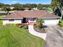 Single-story home with brown roof, landscaping, and a walkway to the entrance at 1621 Texas Ct, Tavares, FL 32778