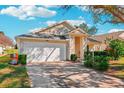 House exterior showcasing a white garage door and landscaping at 25004 Cranes Roost Cir, Leesburg, FL 34748