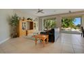 Living room with tiled floors, a leather couch, and views of the pool at 4236 Fawn Meadows Cir, Clermont, FL 34711