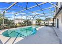 Kidney shaped swimming pool with screened enclosure at 8021 Cardinal Winds Ln, Mascotte, FL 34753