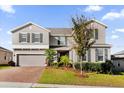 Two-story house with gray siding, brick driveway, and landscaping at 1150 Blarney St, Minneola, FL 34715