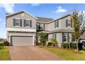 Two-story house with gray siding, brick driveway, and landscaping at 1150 Blarney St, Minneola, FL 34715