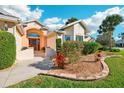 Landscaped front yard with colorful flowers and shrubs at 1589 Arial Pl, The Villages, FL 32162