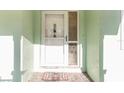 White front door with a glass sidelight and doormat at 17469 Sw 35Th Avenue Rd, Ocala, FL 34473