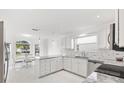 Modern white kitchen with granite countertops and stainless steel appliances at 2051 Palo Alto Ave, The Villages, FL 32159