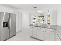 Modern kitchen, featuring stainless steel refrigerator and white cabinetry at 2051 Palo Alto Ave, The Villages, FL 32159