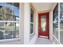 Front entrance with a red door and sidelights, screened porch at 5107 Aurora Dr, Leesburg, FL 34748