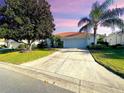 Single-story home with a two-car garage and landscaped lawn at 5336 Tidewater St, Leesburg, FL 34748