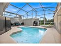 Private screened pool and spa with patio furniture and grill at 840 Pebble Beach Dr, Davenport, FL 33896