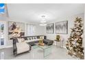 Spacious living room with a sectional sofa, glass coffee table, and decorated Christmas tree at 1087 Welch Hill Cir, Apopka, FL 32712