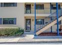 Front entrance of a two-story condo unit with blue railing and stairs at 110 N Tremain St # 110, Mount Dora, FL 32757