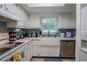 Bright kitchen featuring white cabinets, blue tiled backsplash, and stainless steel appliances at 110 N Tremain St # 110, Mount Dora, FL 32757