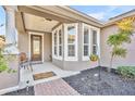Covered porch entry with a bay window and a sitting area at 504 Narrow View Ln, Groveland, FL 34736