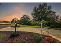 Landscaped front yard with a paved driveway and beautiful sunset view at 5301 Tangelo St, Leesburg, FL 34748